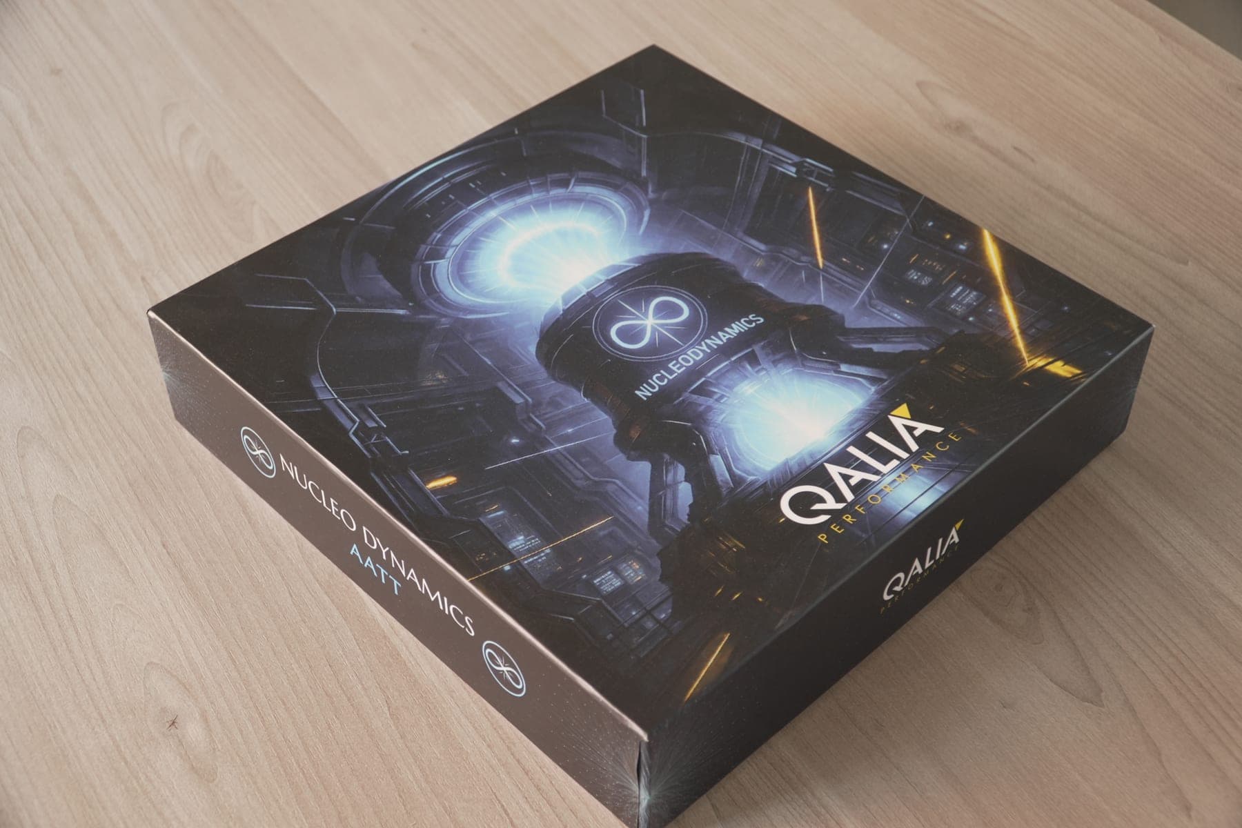 La boîte du jeu Nucleo Dynamics AATT éditée par QALIA Performance, illustration de science-fiction industrielle